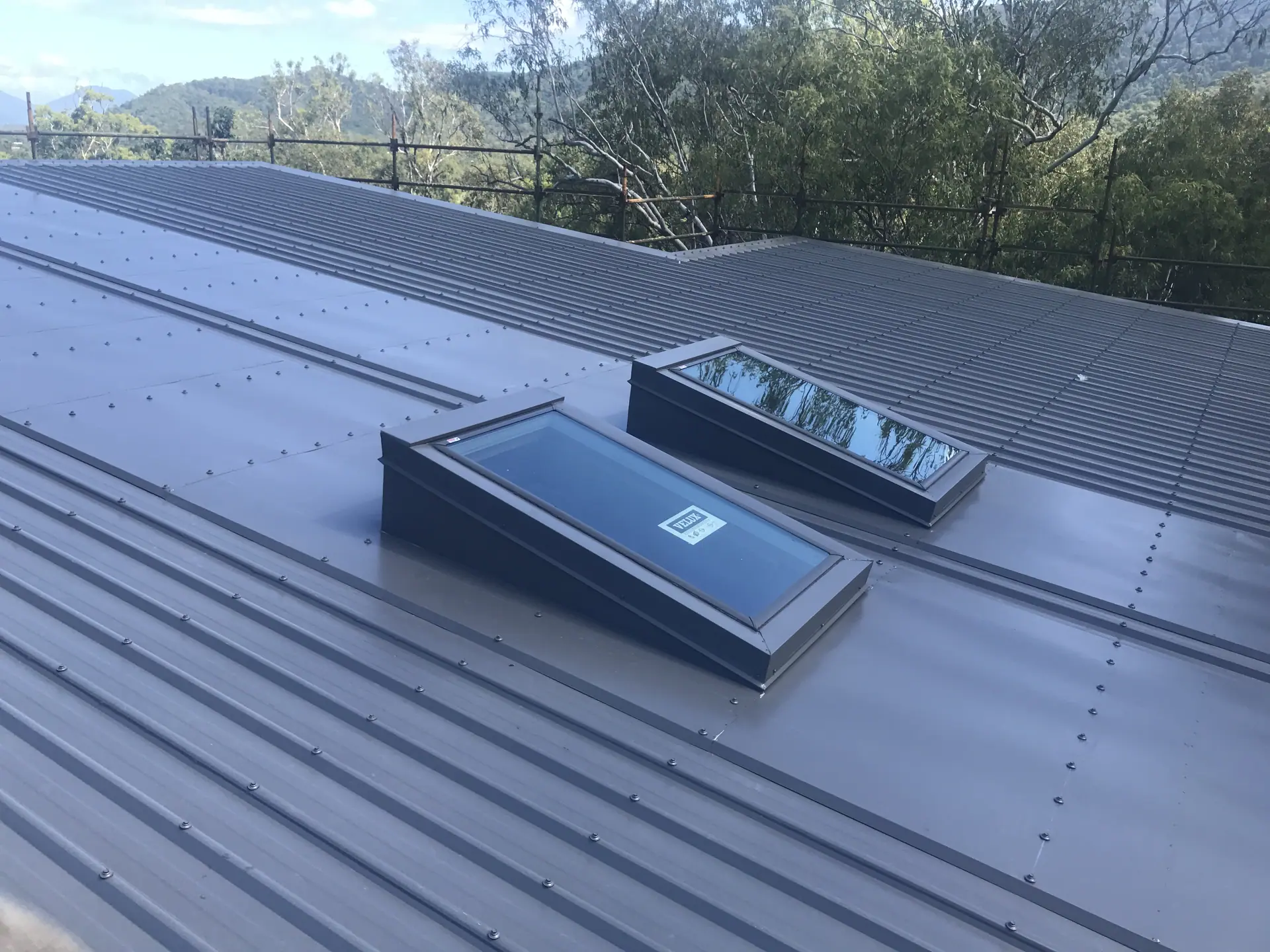 Two skylights installed on a dark metal roof