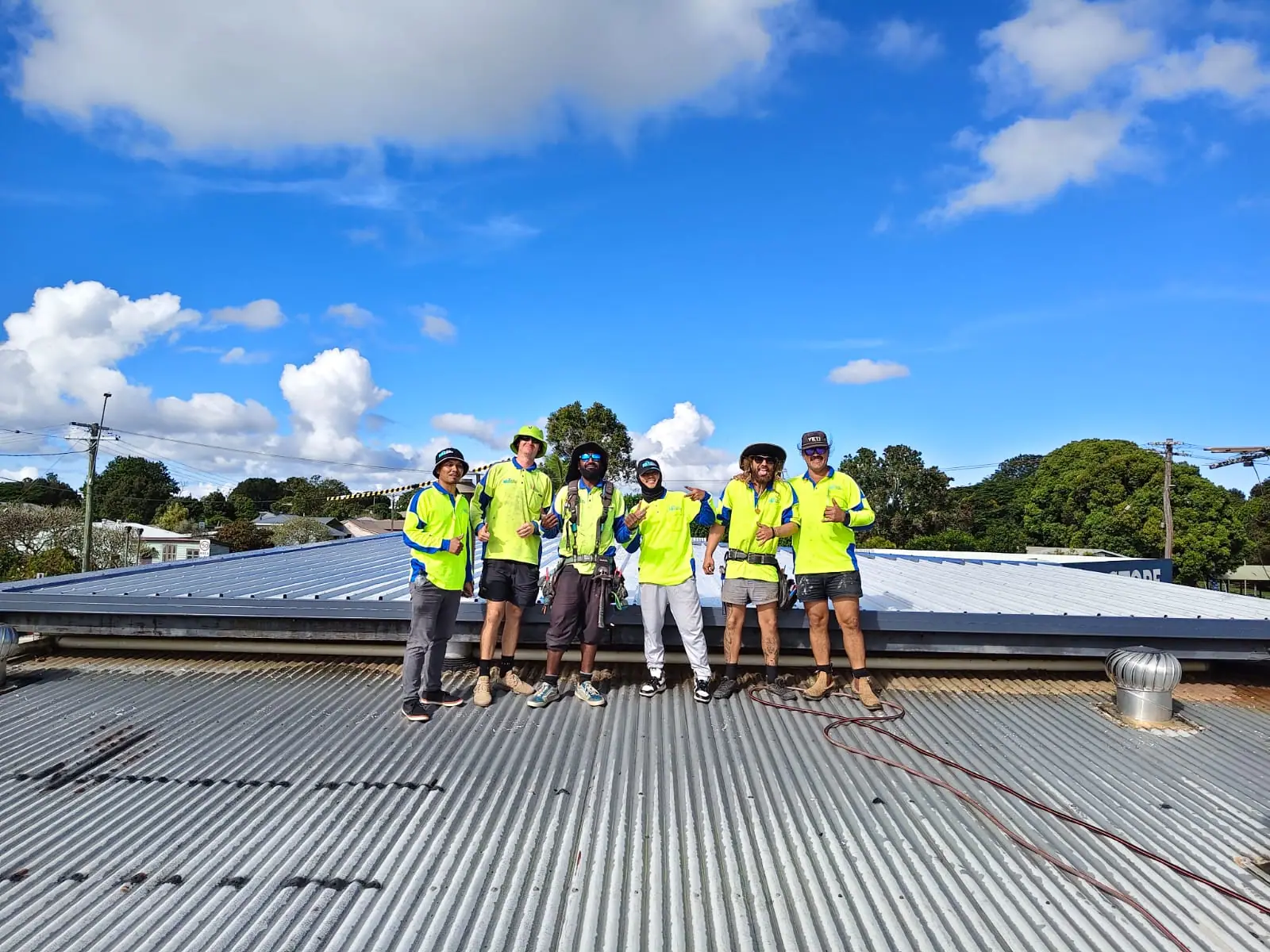 The NBS Metal Roofing crew on a roof in hi-vis shirts